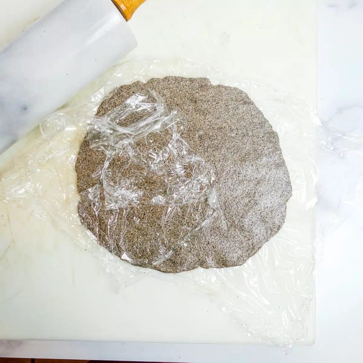chia flatbread dough getting rolled into a round shape