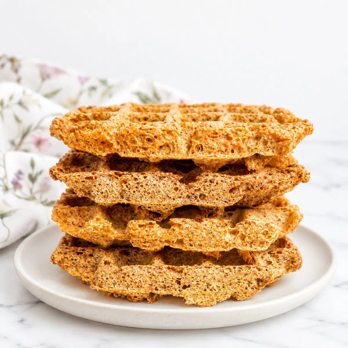 stack of flaxseed waffles on a plate