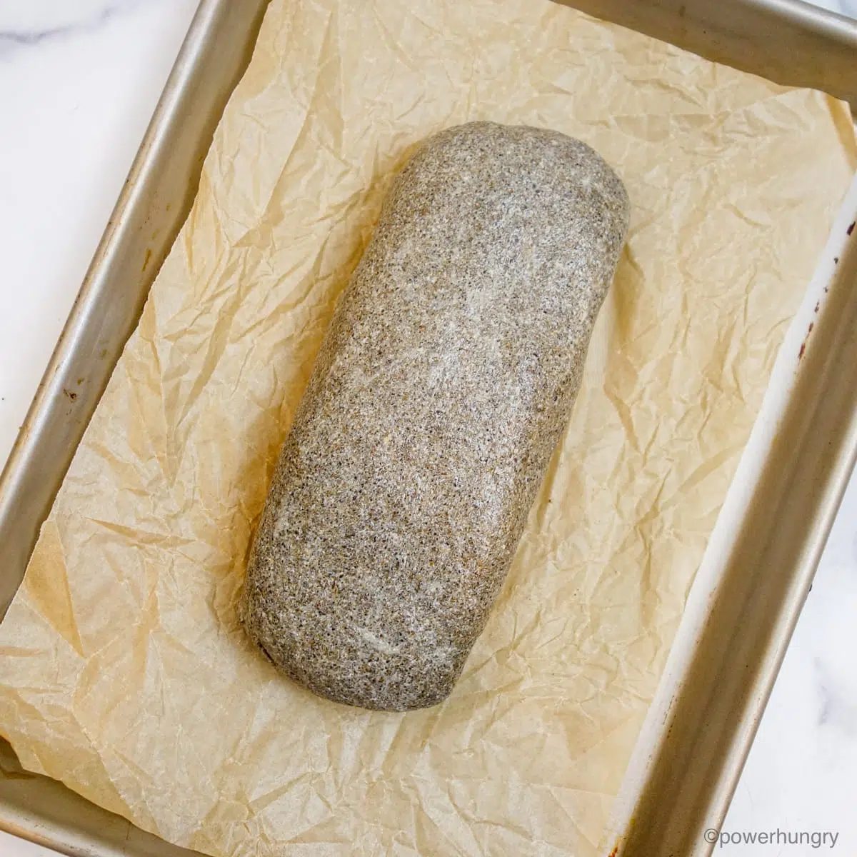 chia sandwich bread sough, shaped into a loaf on a baking sheet