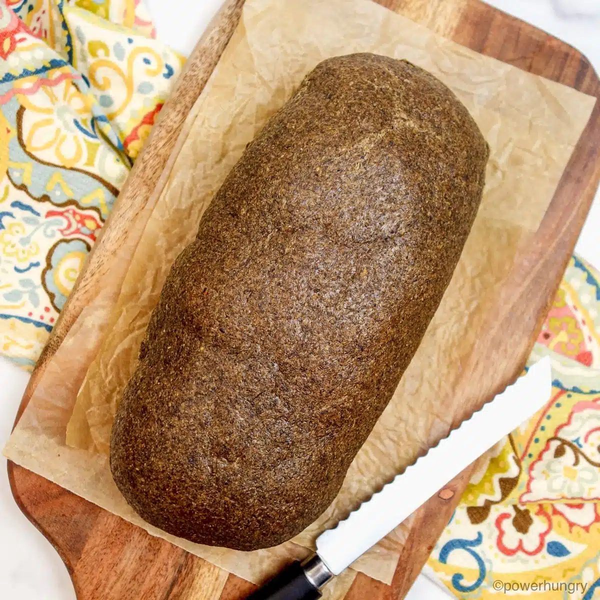 uncut loaf of chia sandwich bread on a cutting board