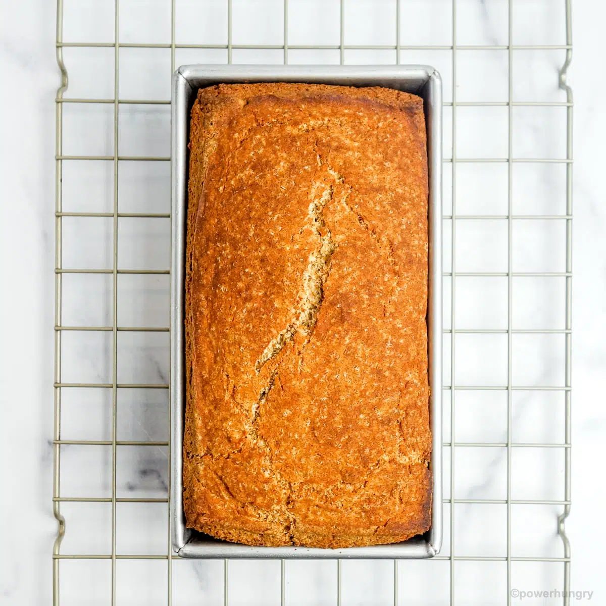 baked millet banana bread on a gold cooling rack