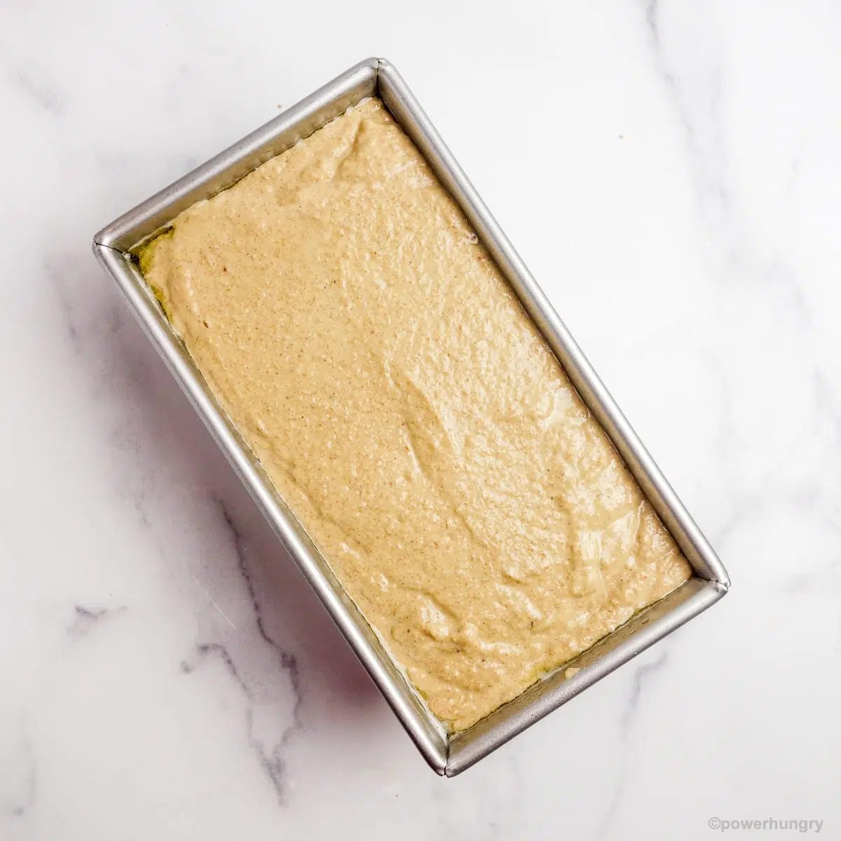 banana bread batter in a metal loaf pan