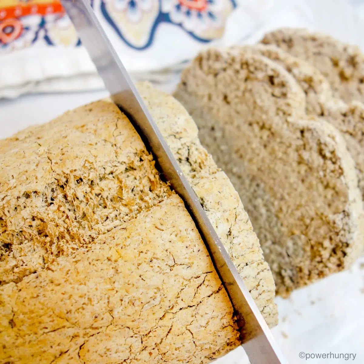 overhead view of a loaf of gluten-free sorghum bread being sliced