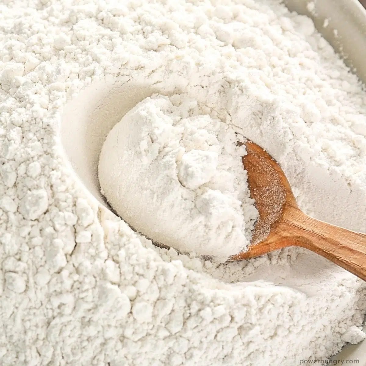 overhead shot of sorghum flour with a wooden spoon