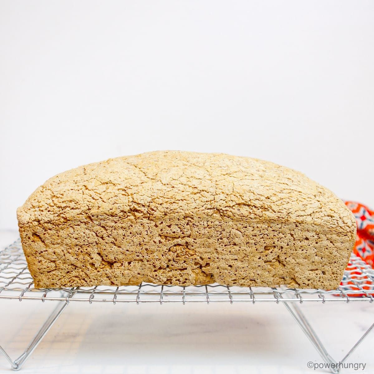 sideways photo of baked sorghum bread on a wire cooling rack