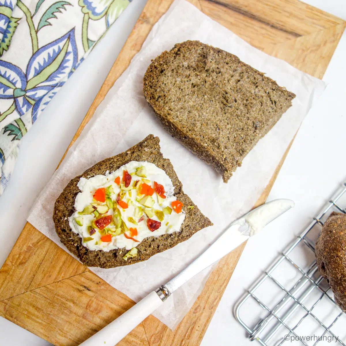 sliced 2 ingredient chia bread spread with vegan cream cheese and chopped dried fruit
