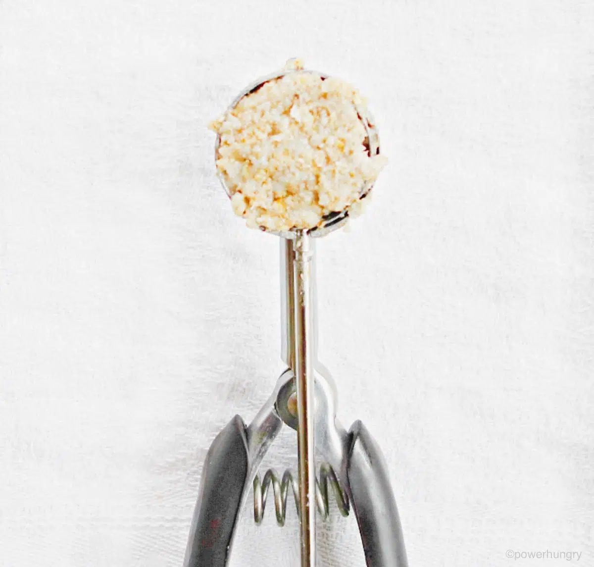 a close up of a cookie scoop filled with banana coconut cookie dough