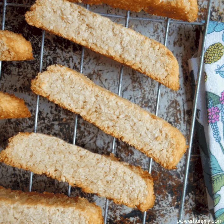 Nourishing coconut biscotti on a wire cooling rack with a floral napkin alongside