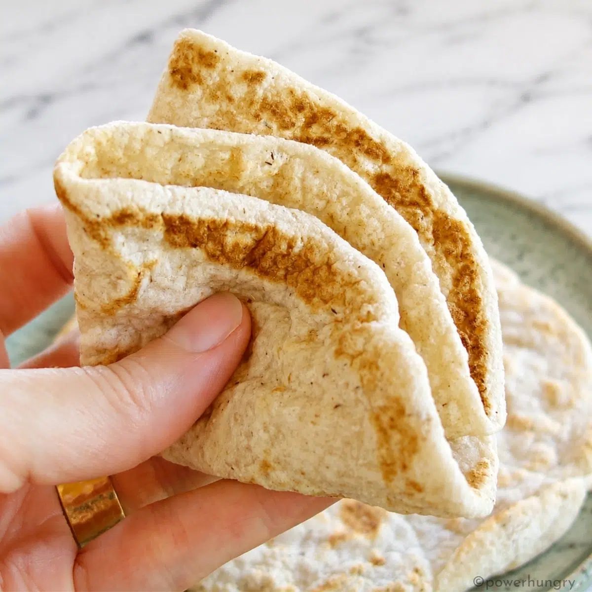 2 ingredient coconut flour tortilla being held , folded, in a hand