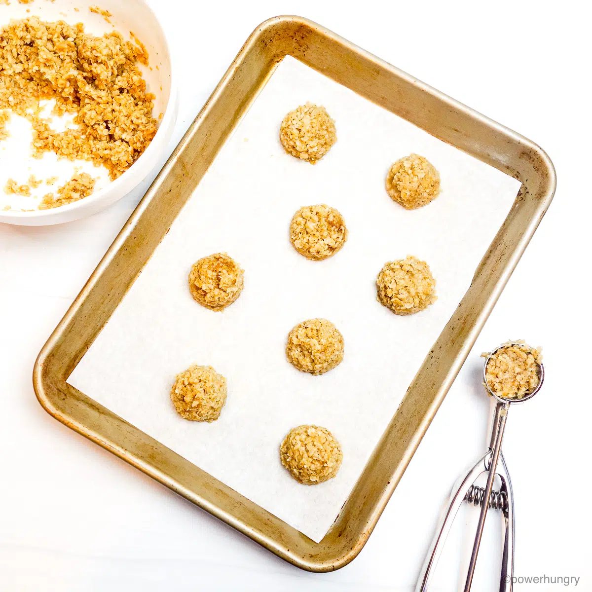 overhead shot of banana millet cookie dough being portioned on a cookie sheet