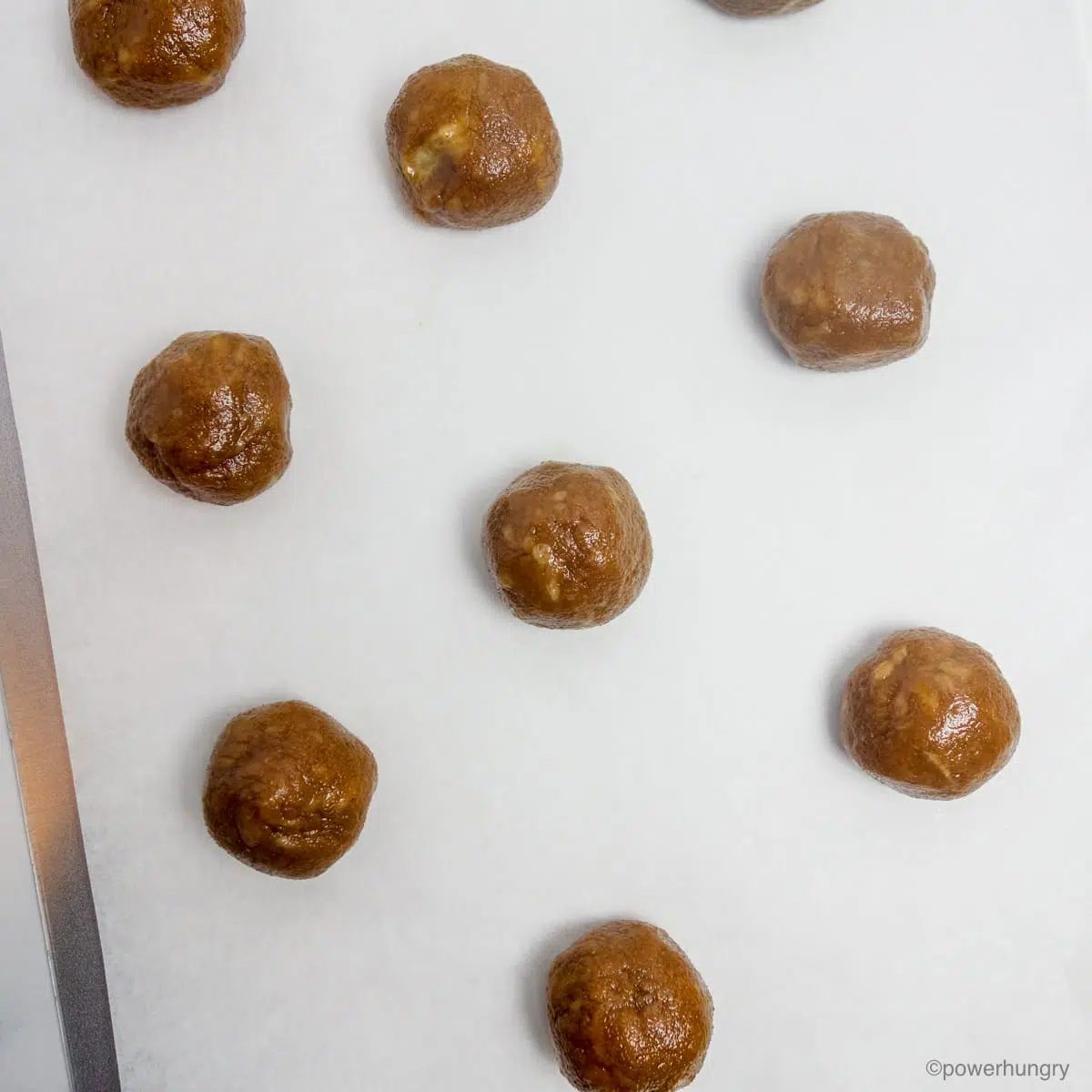 cookie dough balls on a parchment lined baking sheet