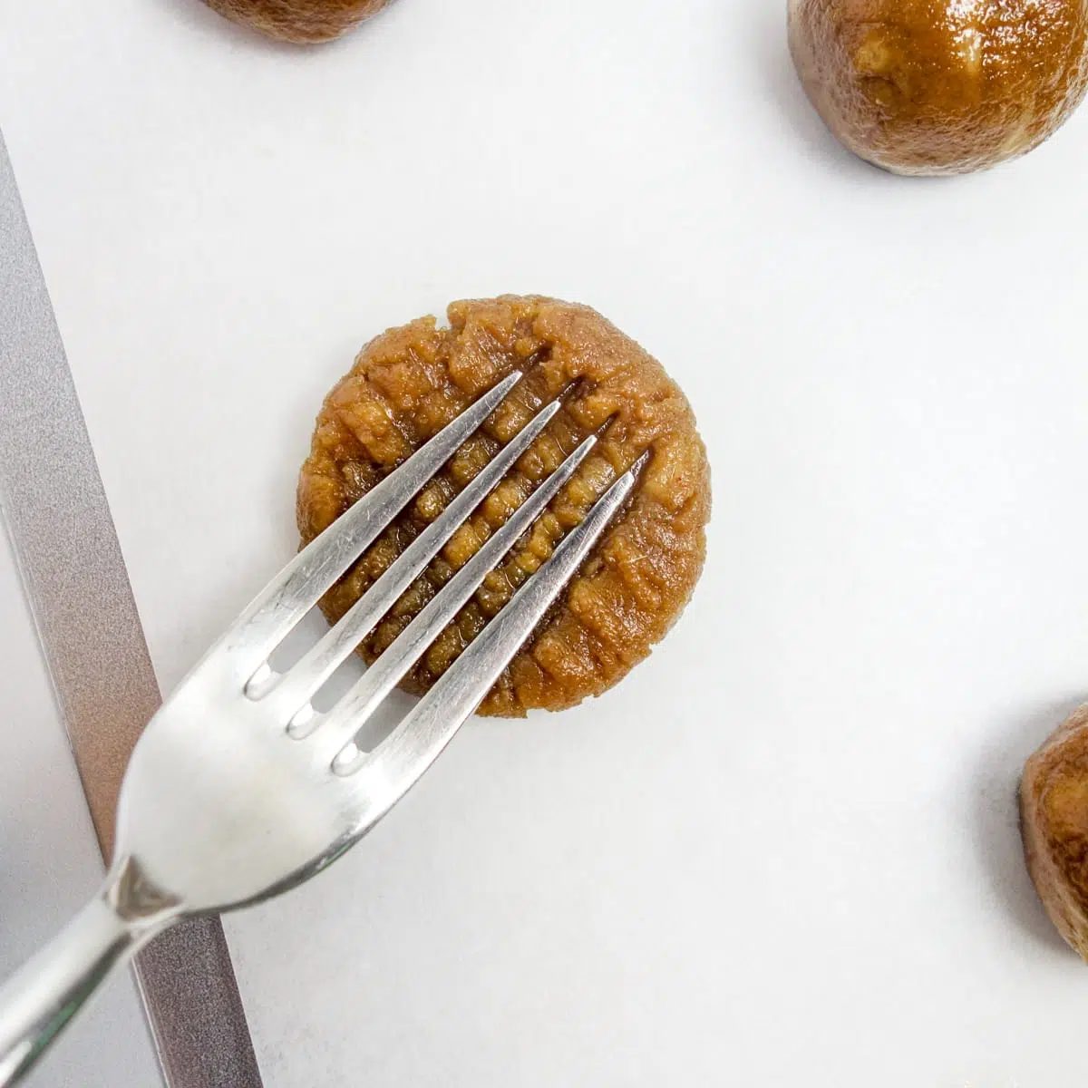 a peanut butter banana cookie getting flattened and marked with a fork