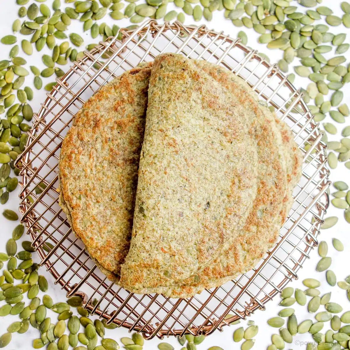 overhead shot of pepita tortillas on a cooling rack surrounded by pepitas