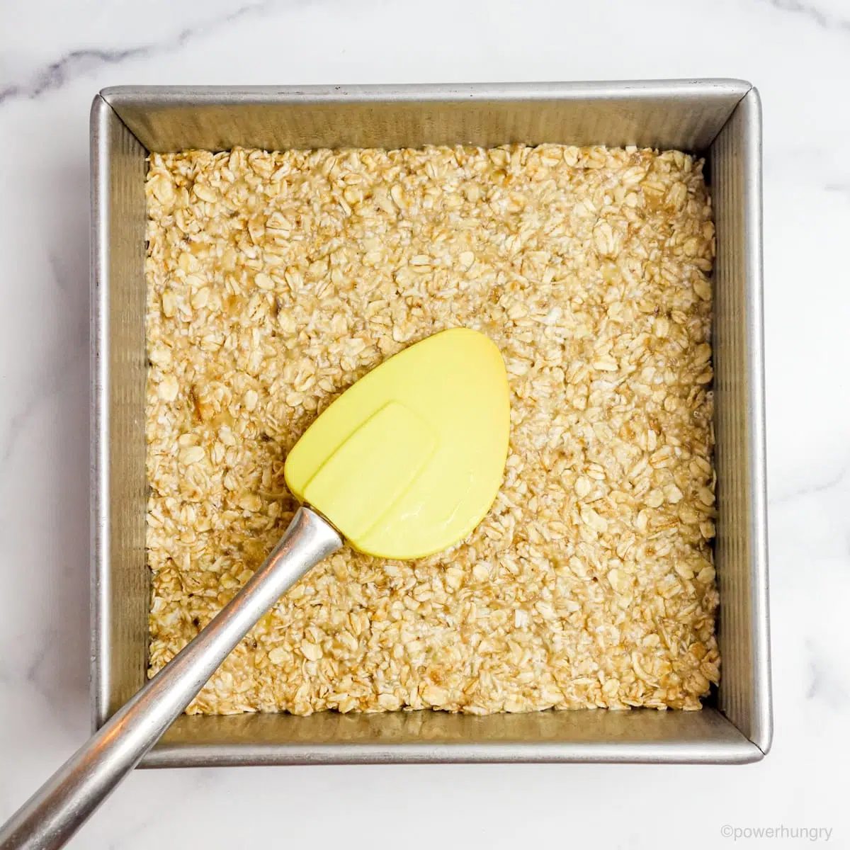 banana oat dough spread in a square baking pan