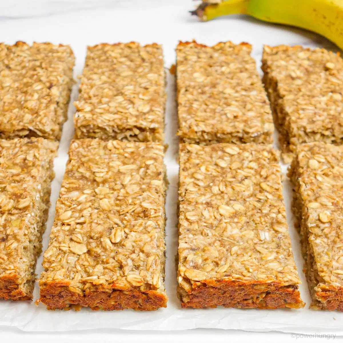 cut banana oat bars on white parchment paper