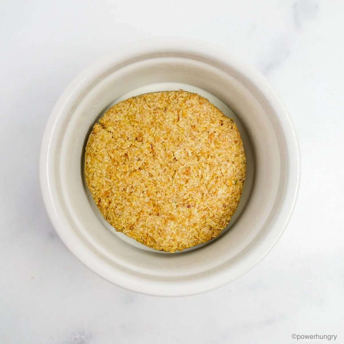 flax dough disk placed in the bottom of a white ramekin