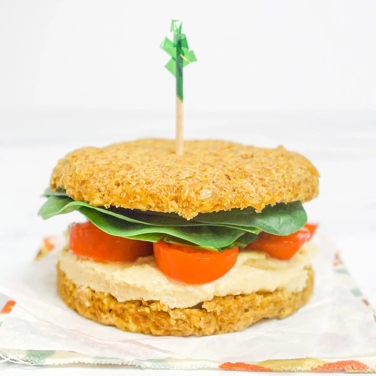 a mini sandwich made with flax brea, hummus, and vegetables
