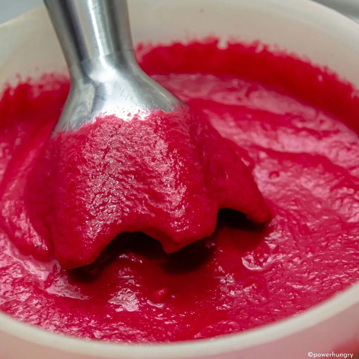 an immersion blender pureeing beet soup