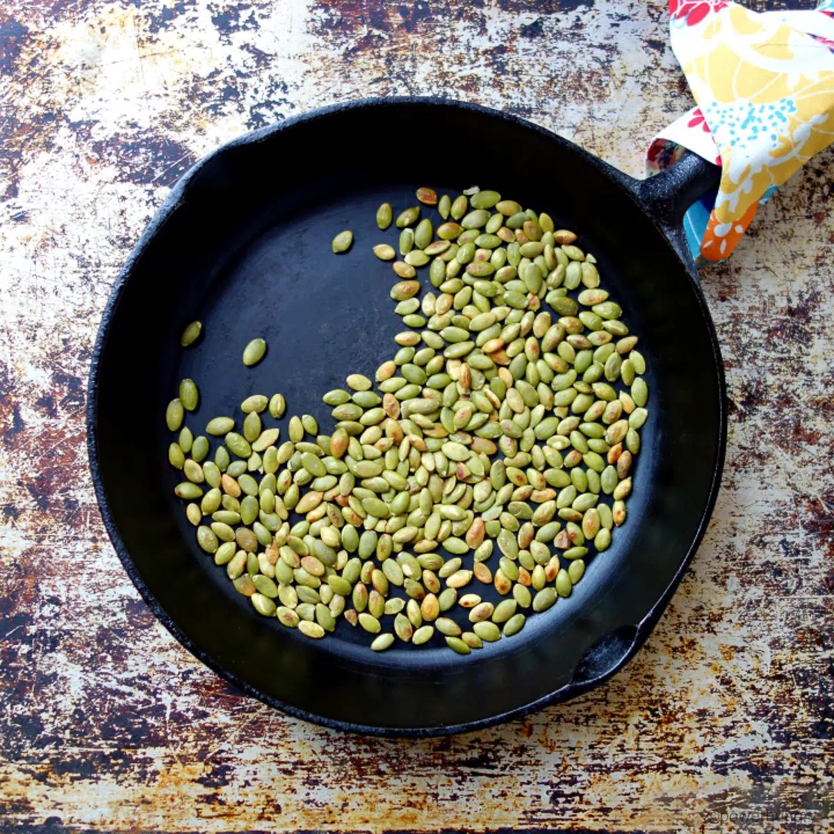 toasted pepitas in a cast iron skillet