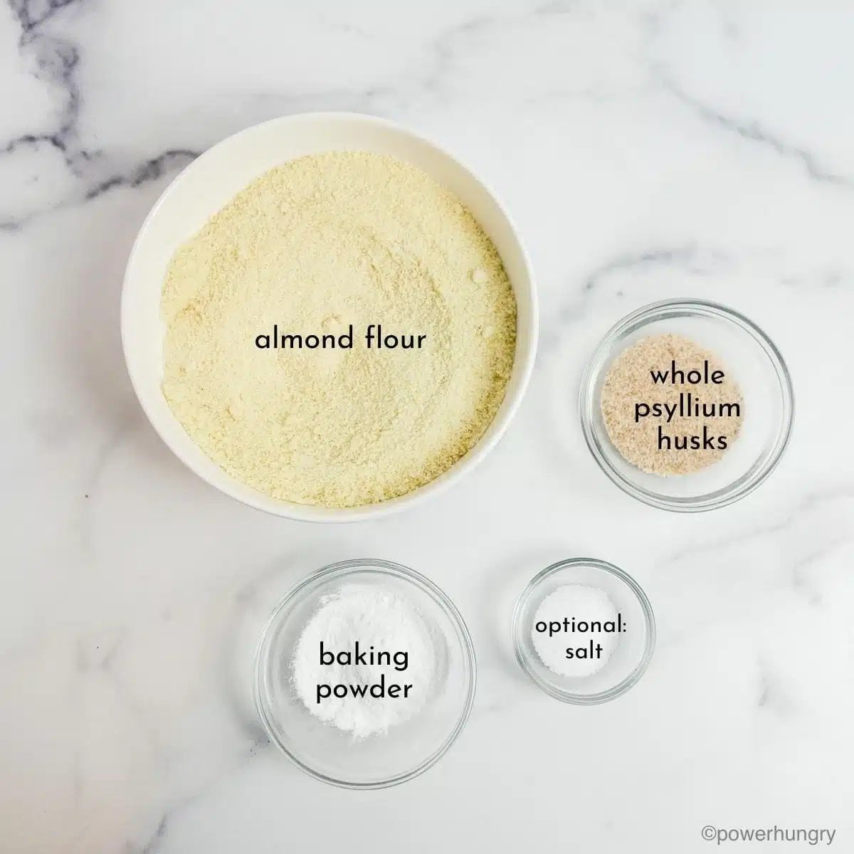 ingredients for almond flour pizza crust on a white marble background