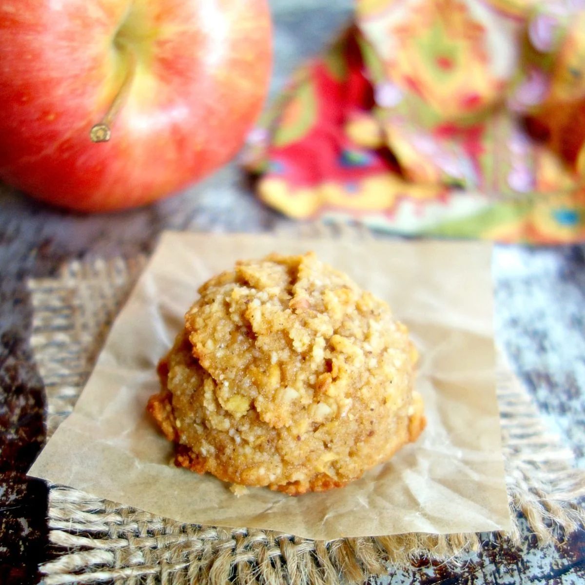 a single 3-ingredient apple almond flour cookie on a piece of parchment paper and burlap