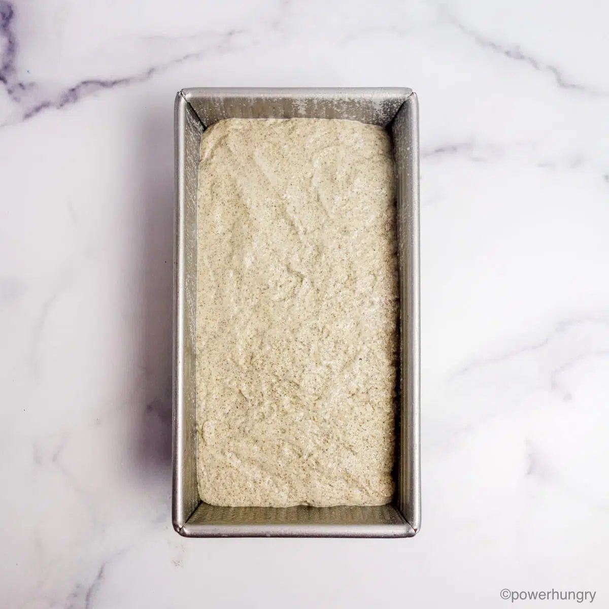 millet chia bread dough in a metal baking tin