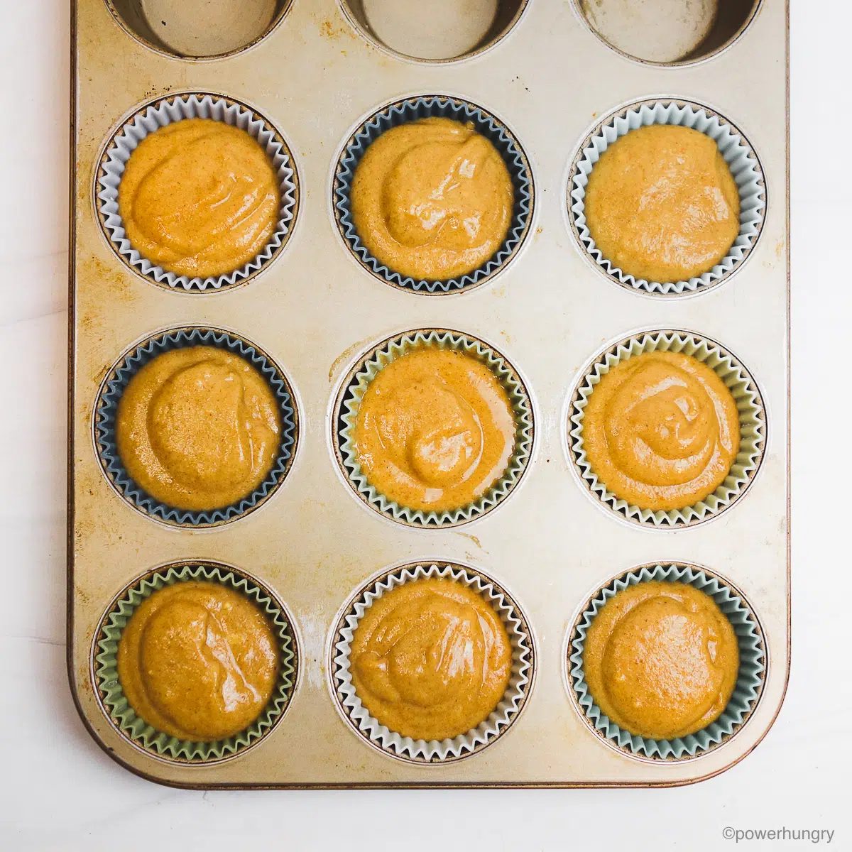 chickpea flour date muffins batter in a muffin tin