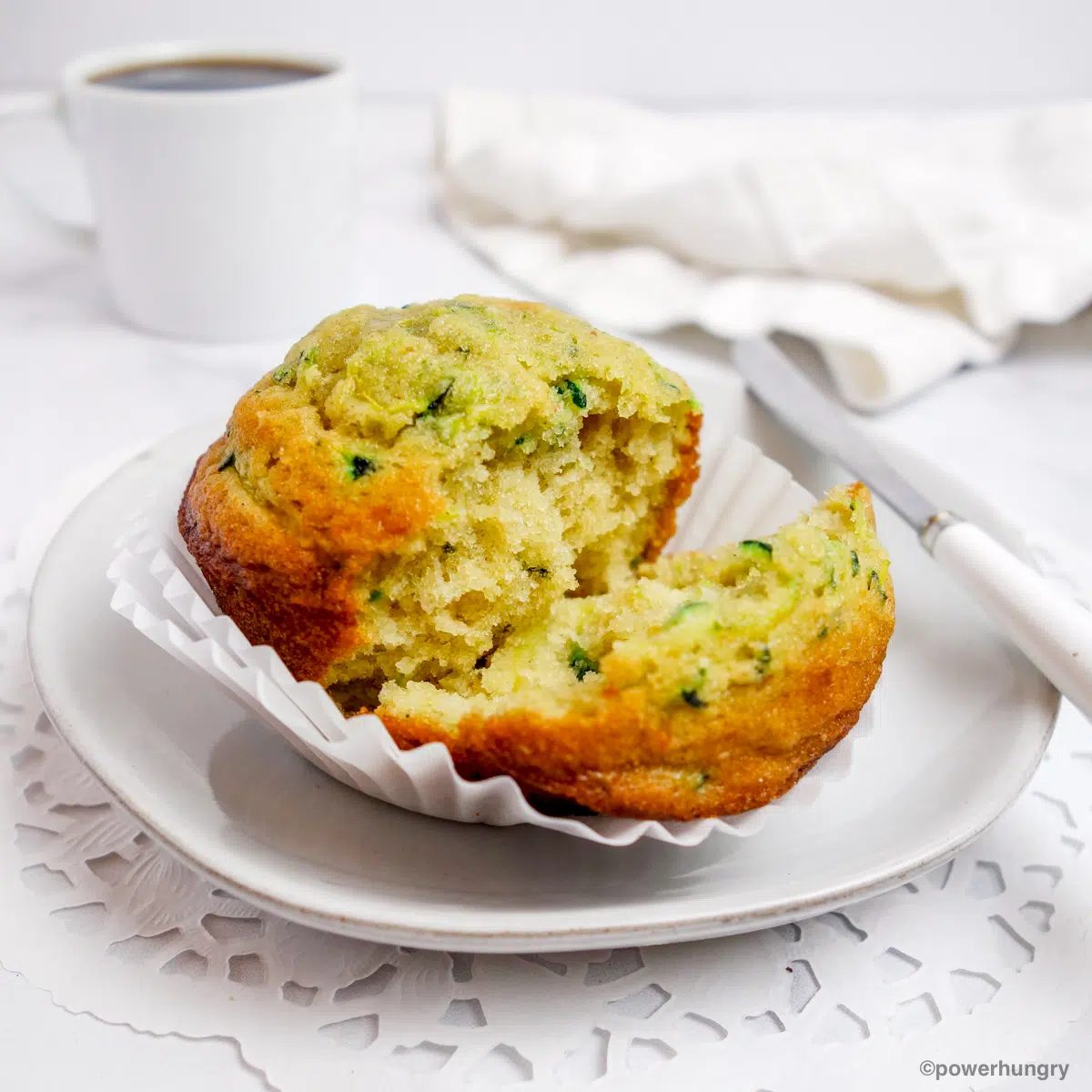 split zucchini muffin on a white plate