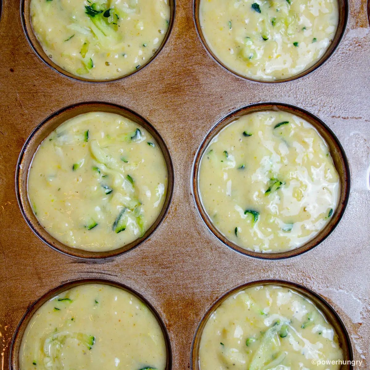 zucchini muffin batter in a muffin tin
