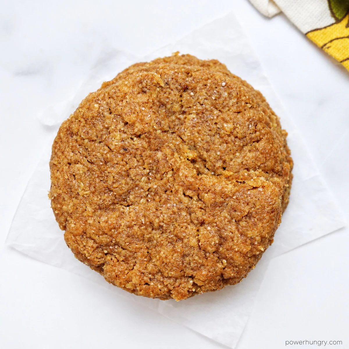 a single flaxseed cookie on a marble background, closeup