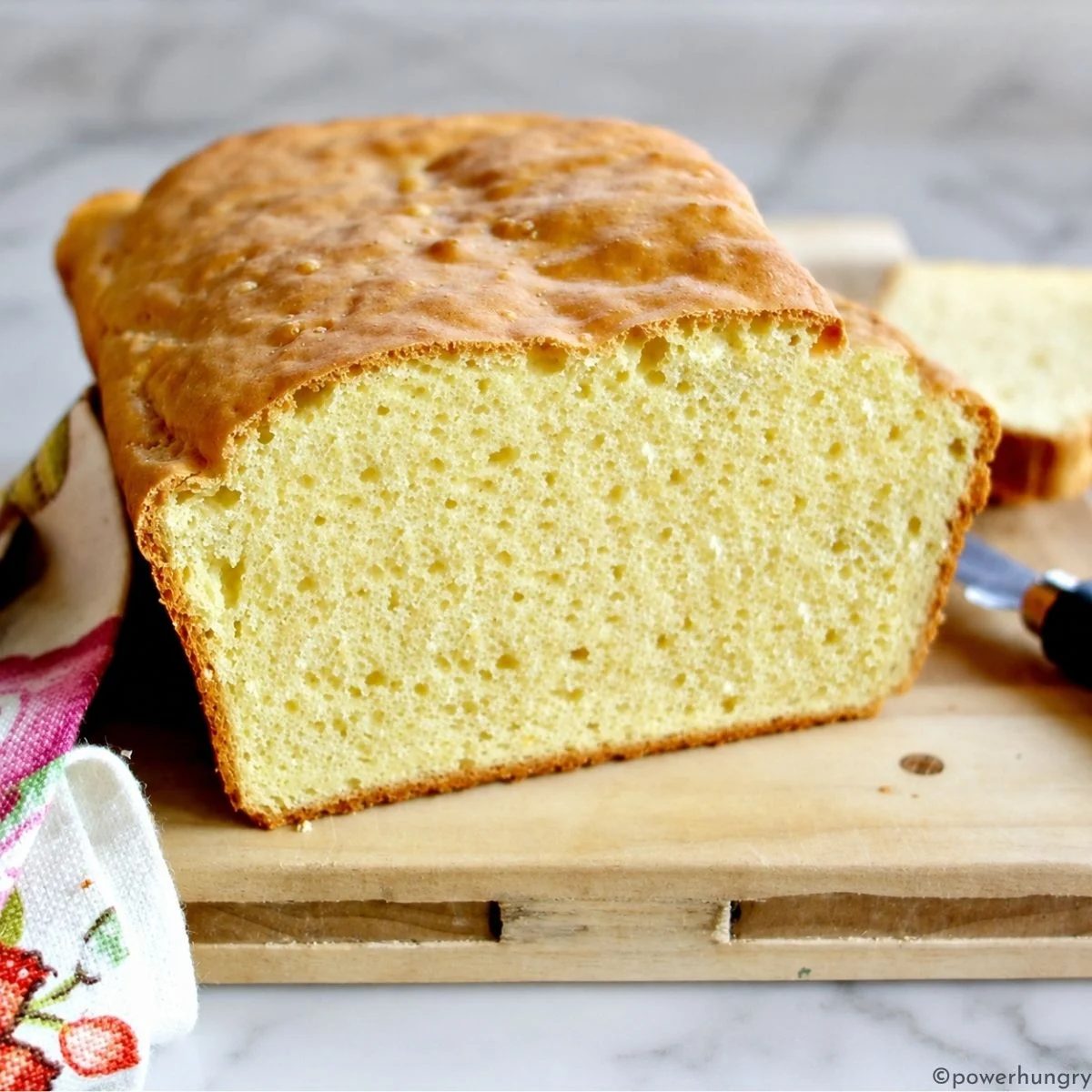 3-ingredient chickpea flour bread on a wooden cutting board, sliced, to show interior
