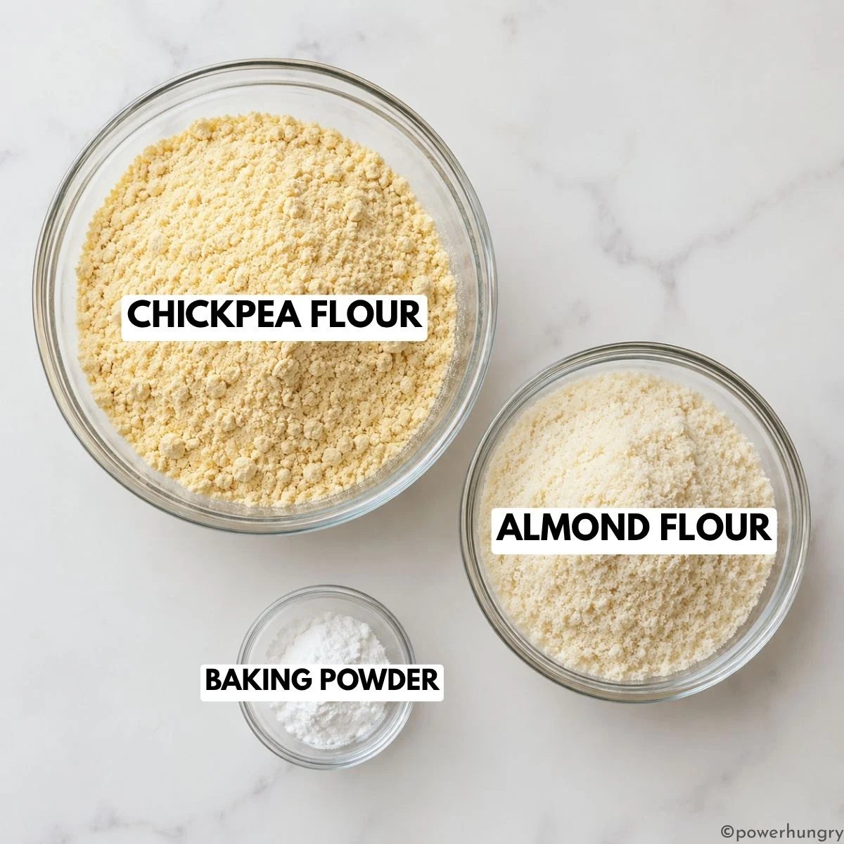 three glass prep bowls filed with almond flour, chickpea flour and baking powderl