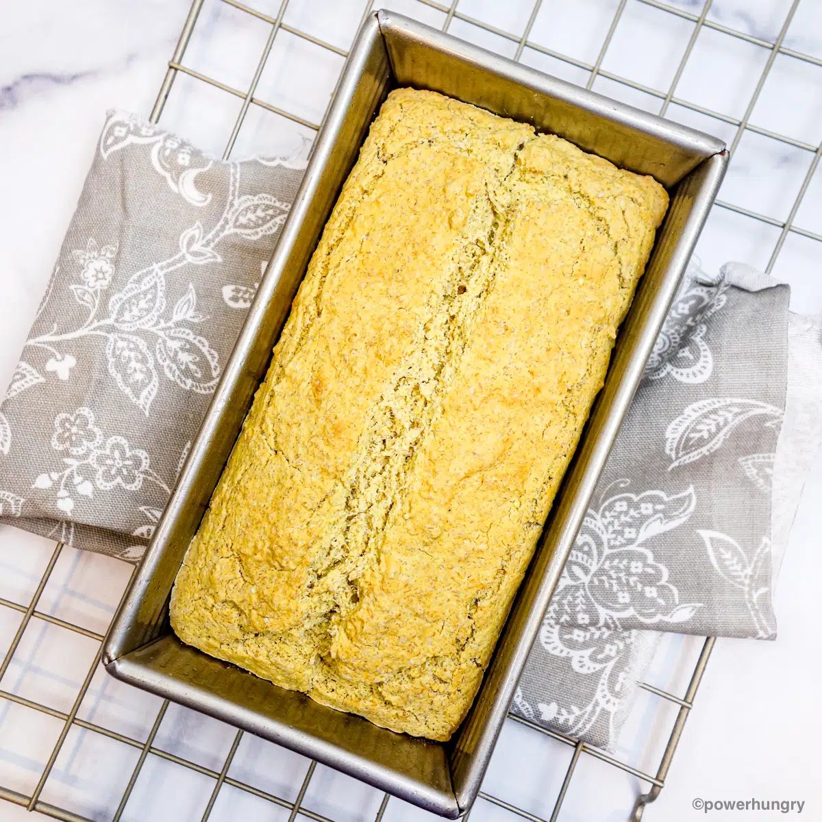 baked loaf of millet flax bread in a tin pan