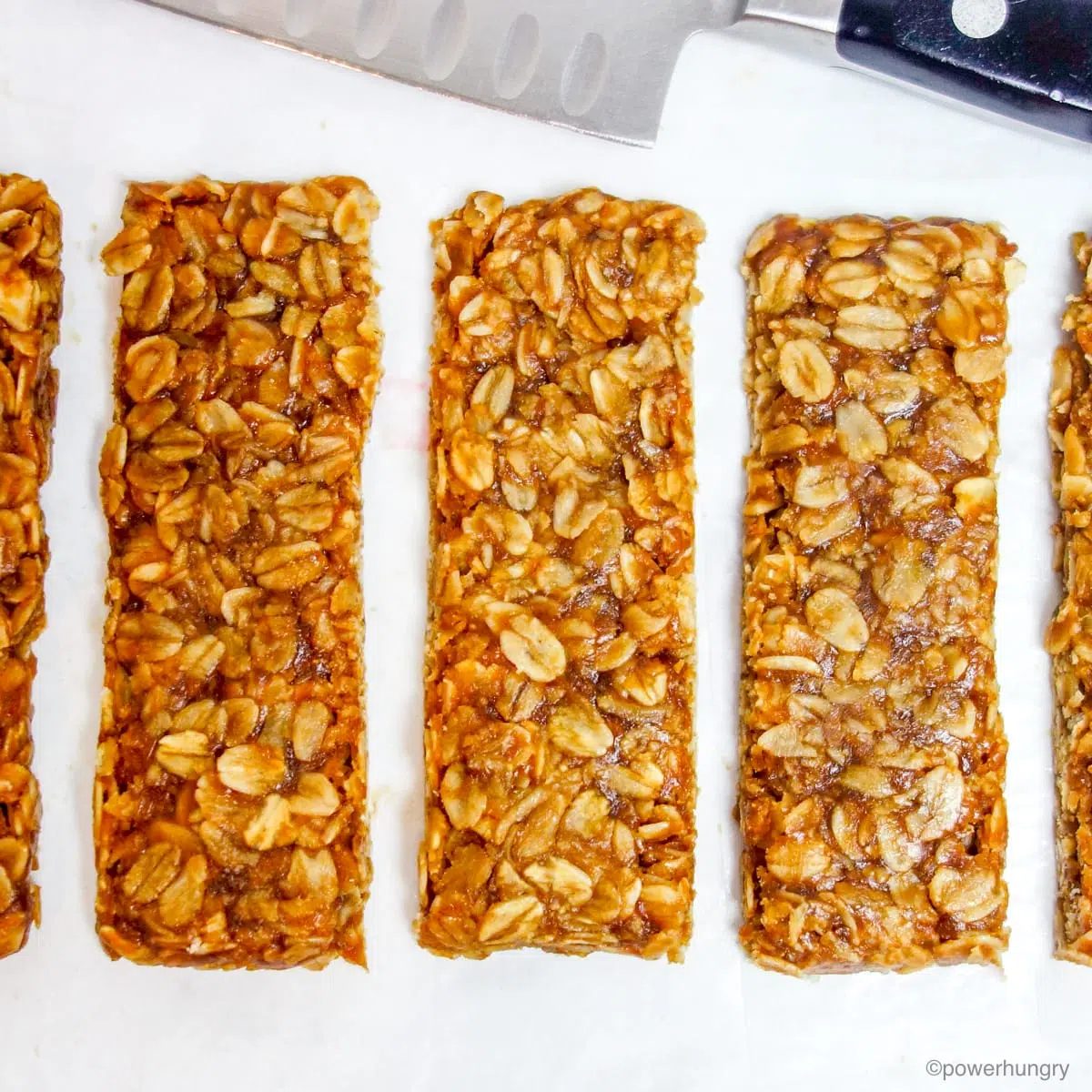 3 ingredient no bake granola bars, cut on a piece of white parchment paper