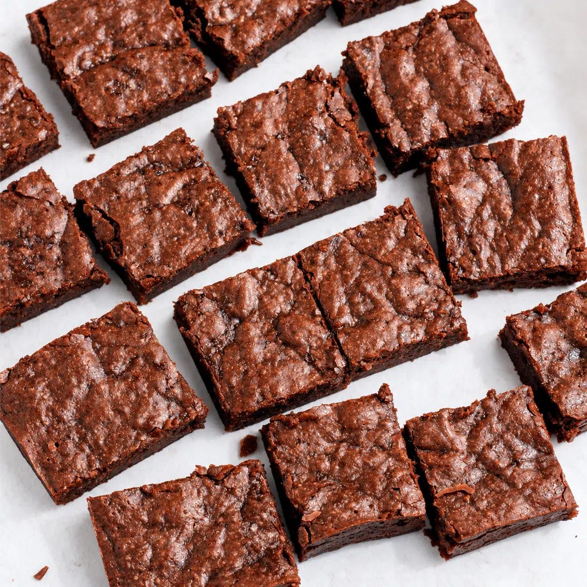 cut sweet potato brownies on white parchment paper