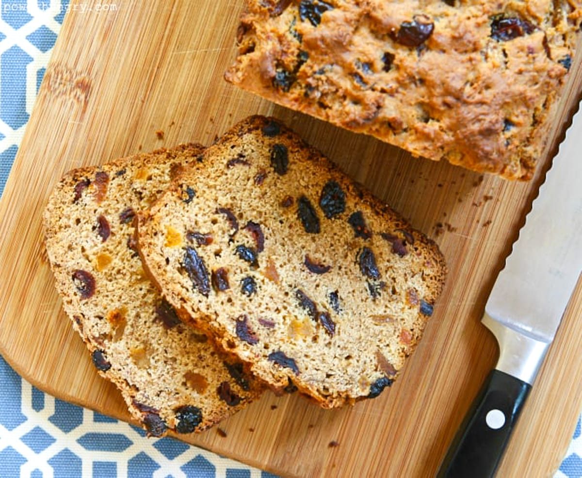 a loaf of slice bara brith, Welsh fruit bread, on a wood cutting board