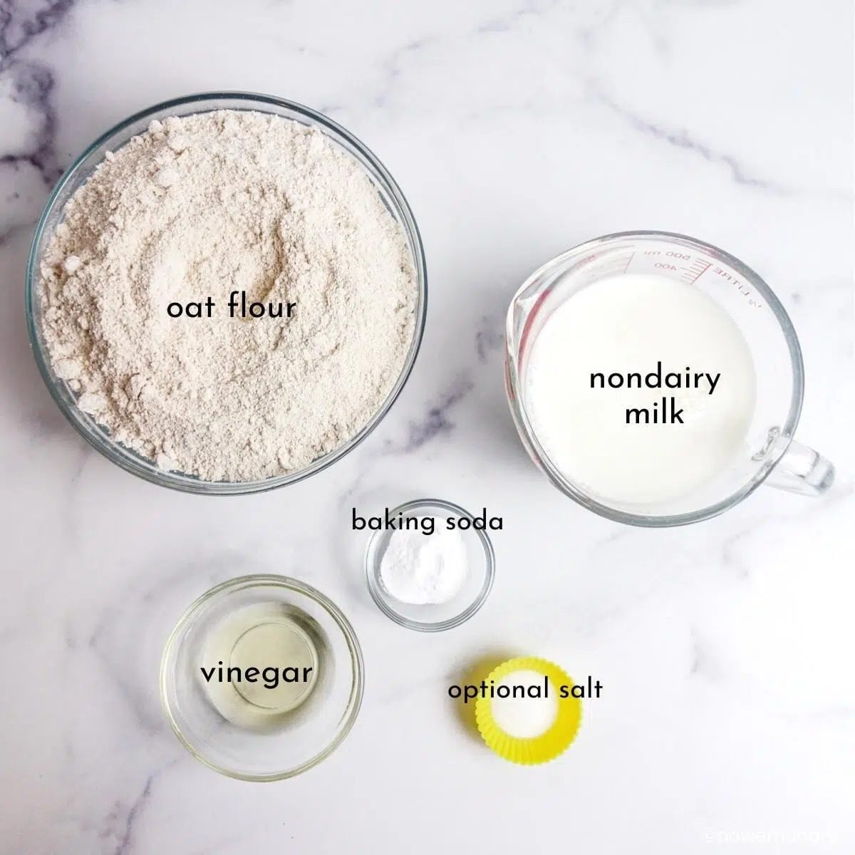 overhead shot of glass bowls filled with the ingredients for oat flour bread