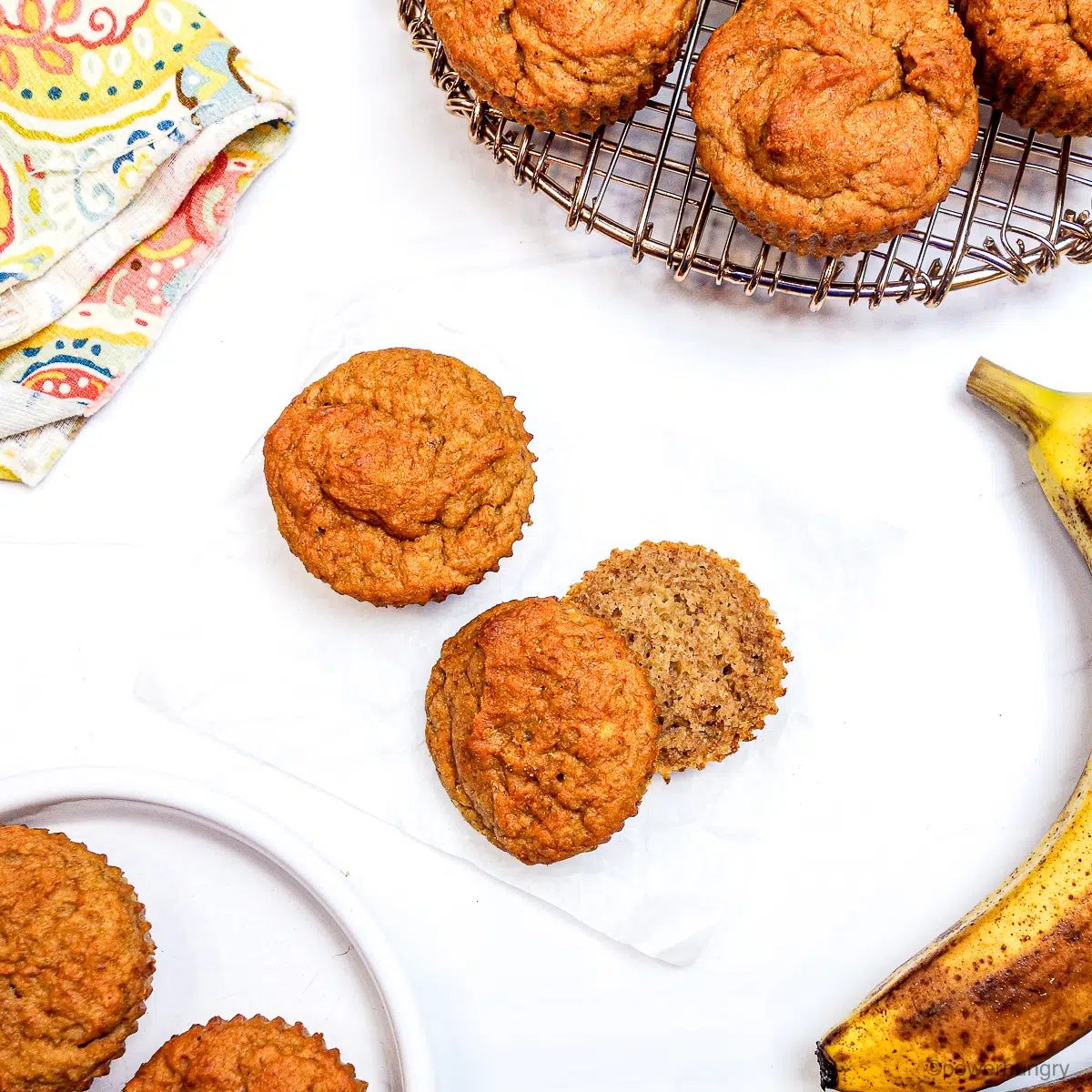 overhead shot of multiple cassava flour banana muffins on a white marble surface