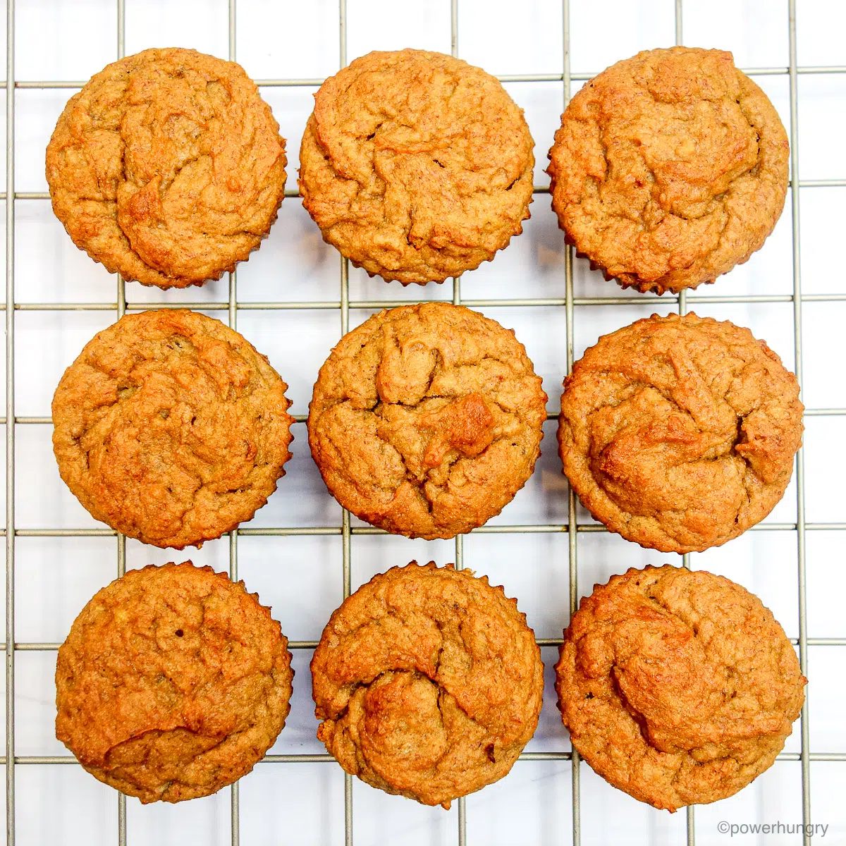 overhead shot of banana muffins on a gold cooling rack