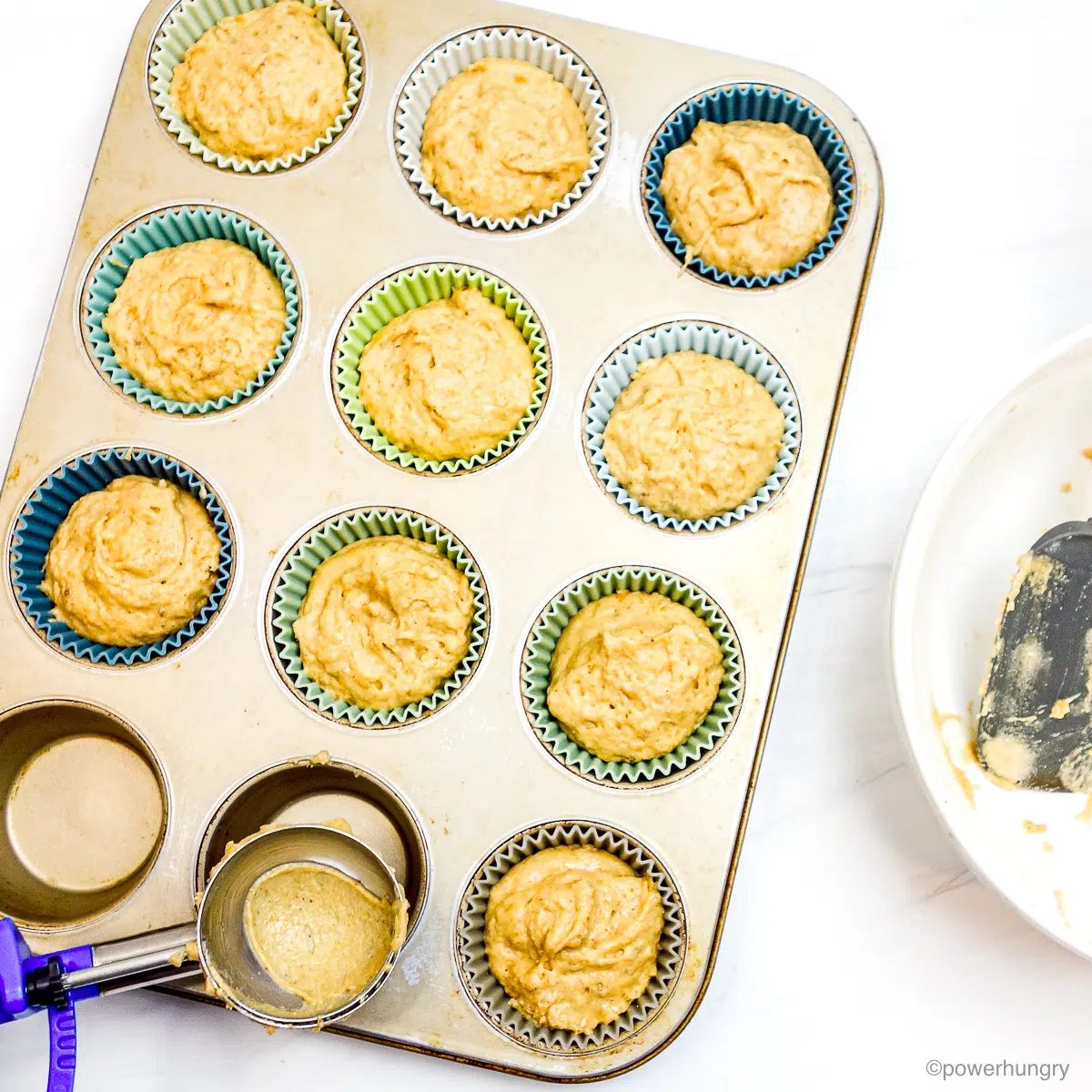 muffin batter spooned into a muffin tin