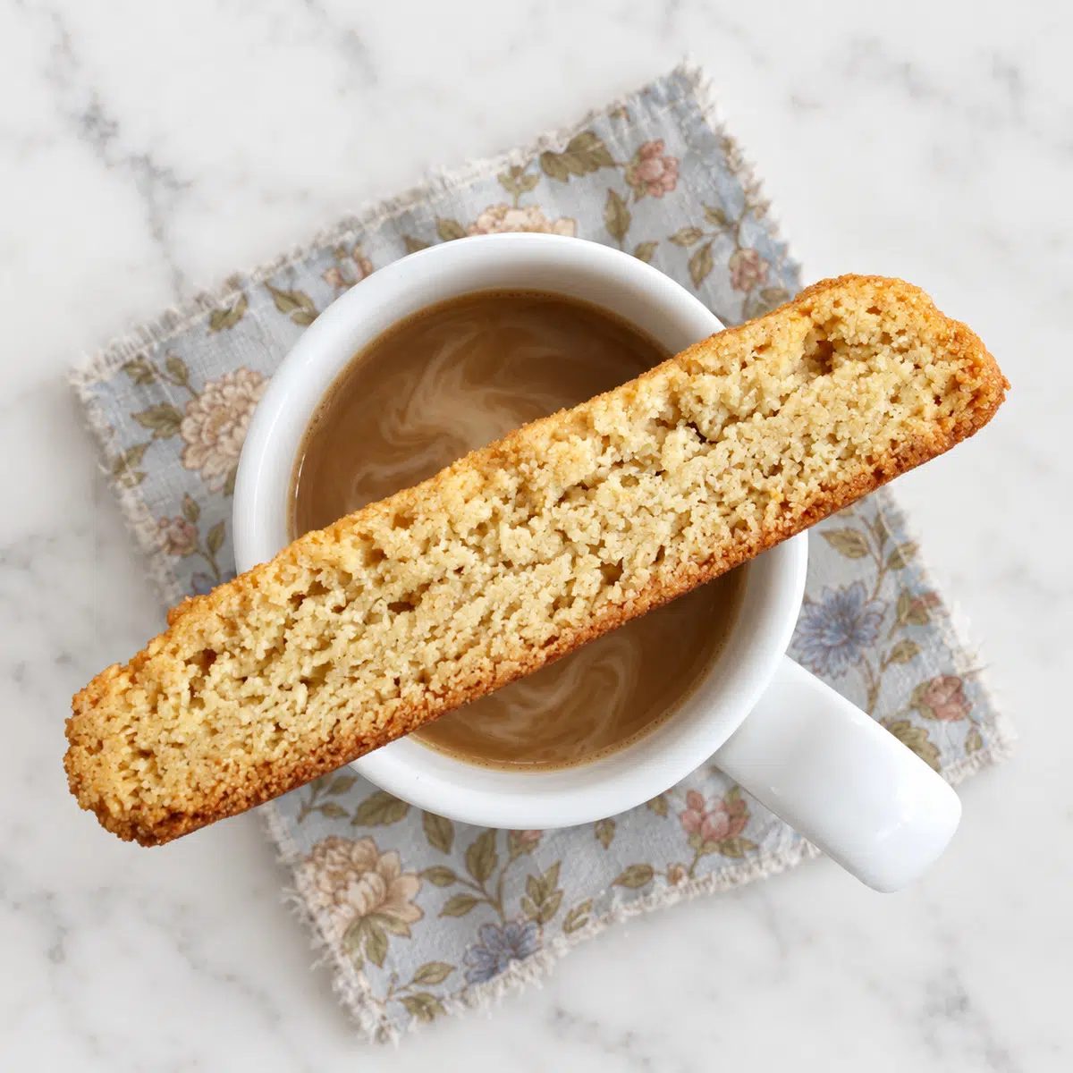 a single vegan almond flour biscotti over a cup of coffee