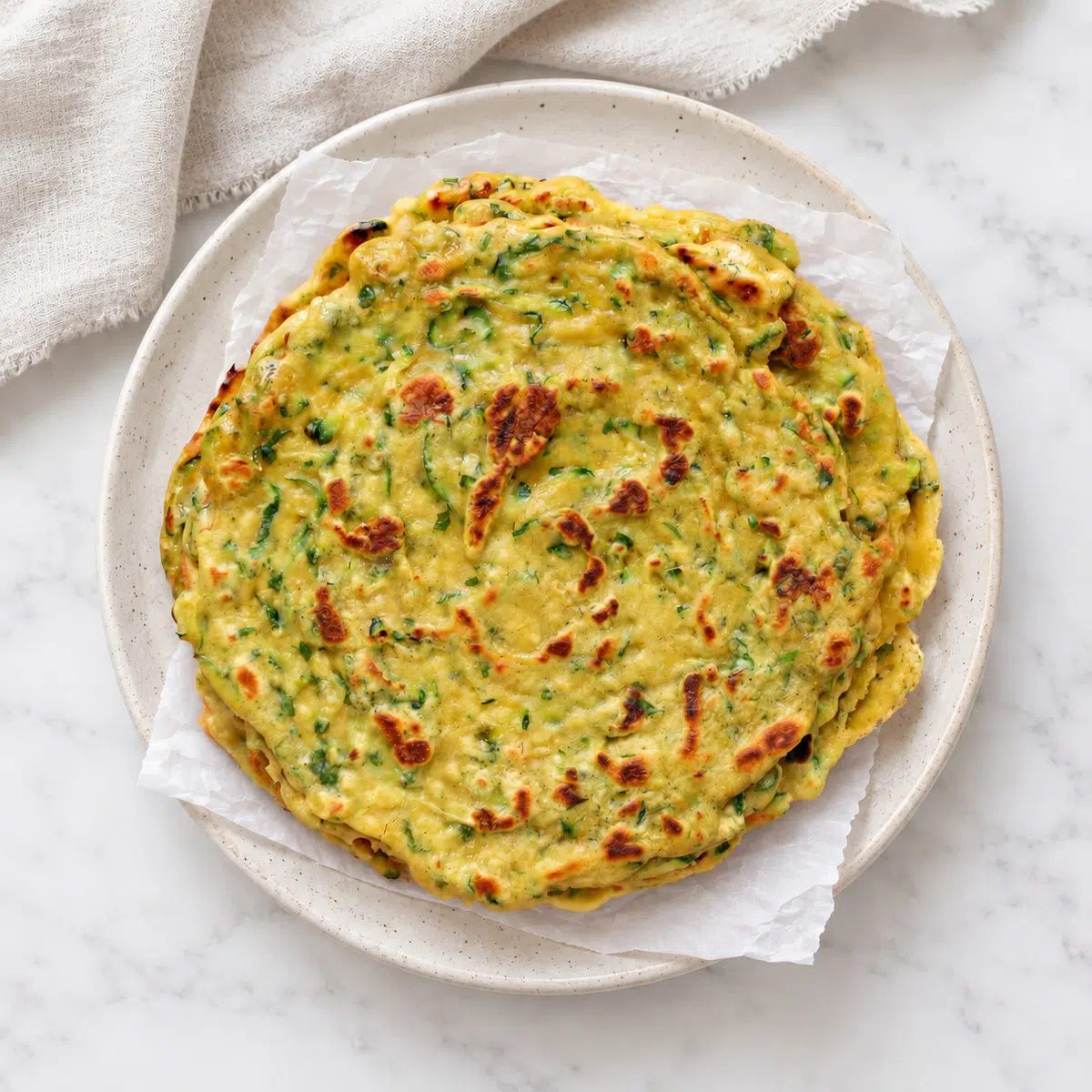 overhead view of zucchini flatbread recipe made with chickpea flour on a stoneware plate