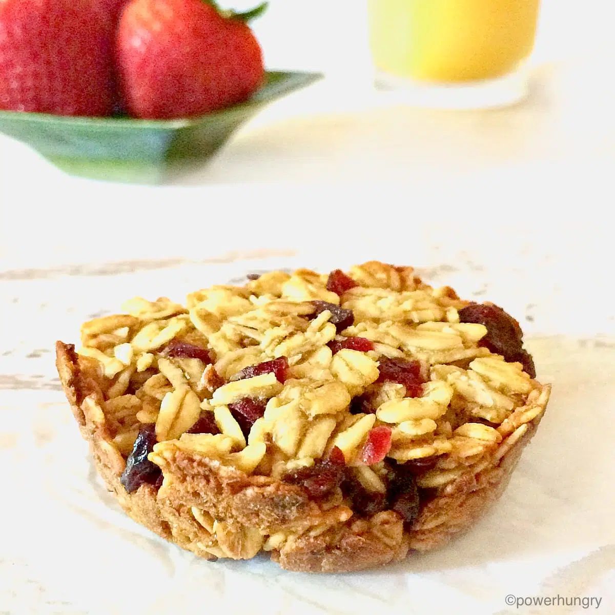 vegan muffin tin granola bar with strawberries and juice in the background