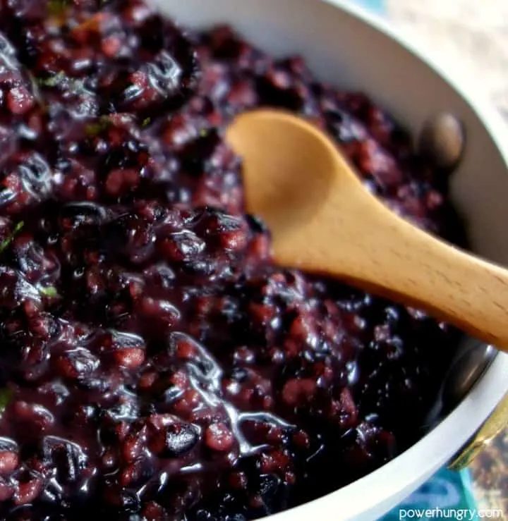 coconut black rice pudding ins a silver dish, close-up