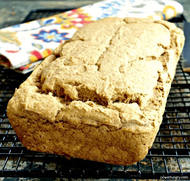 whole loaf of baked lentil bread on a black cooling rack