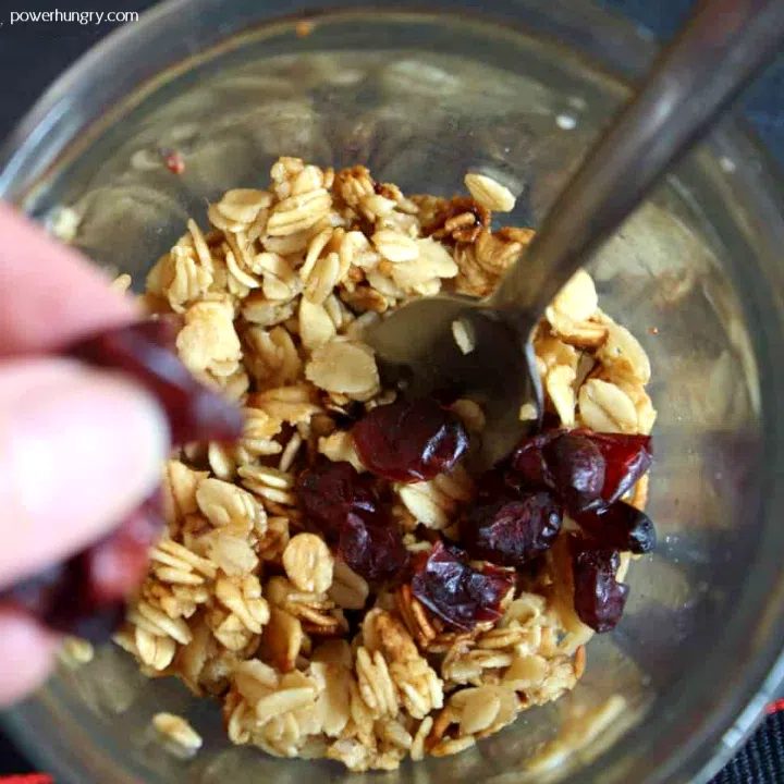 adding dried cranberries to just cooked microwave mug granola