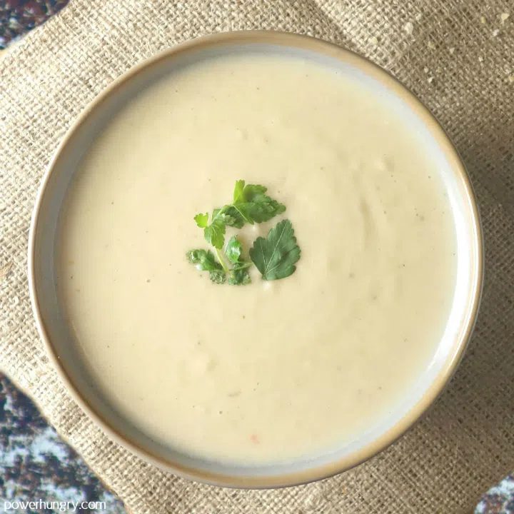 overhead shot of chickpea flour soup in a bowl with a parsley garnish.