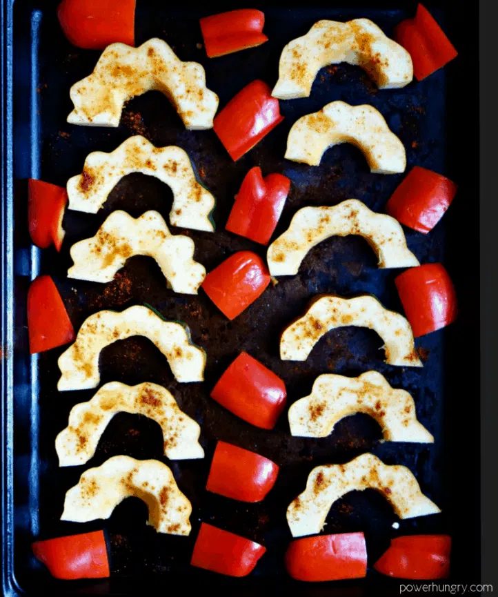 acorn squash and red bell peppers on a sheet pan