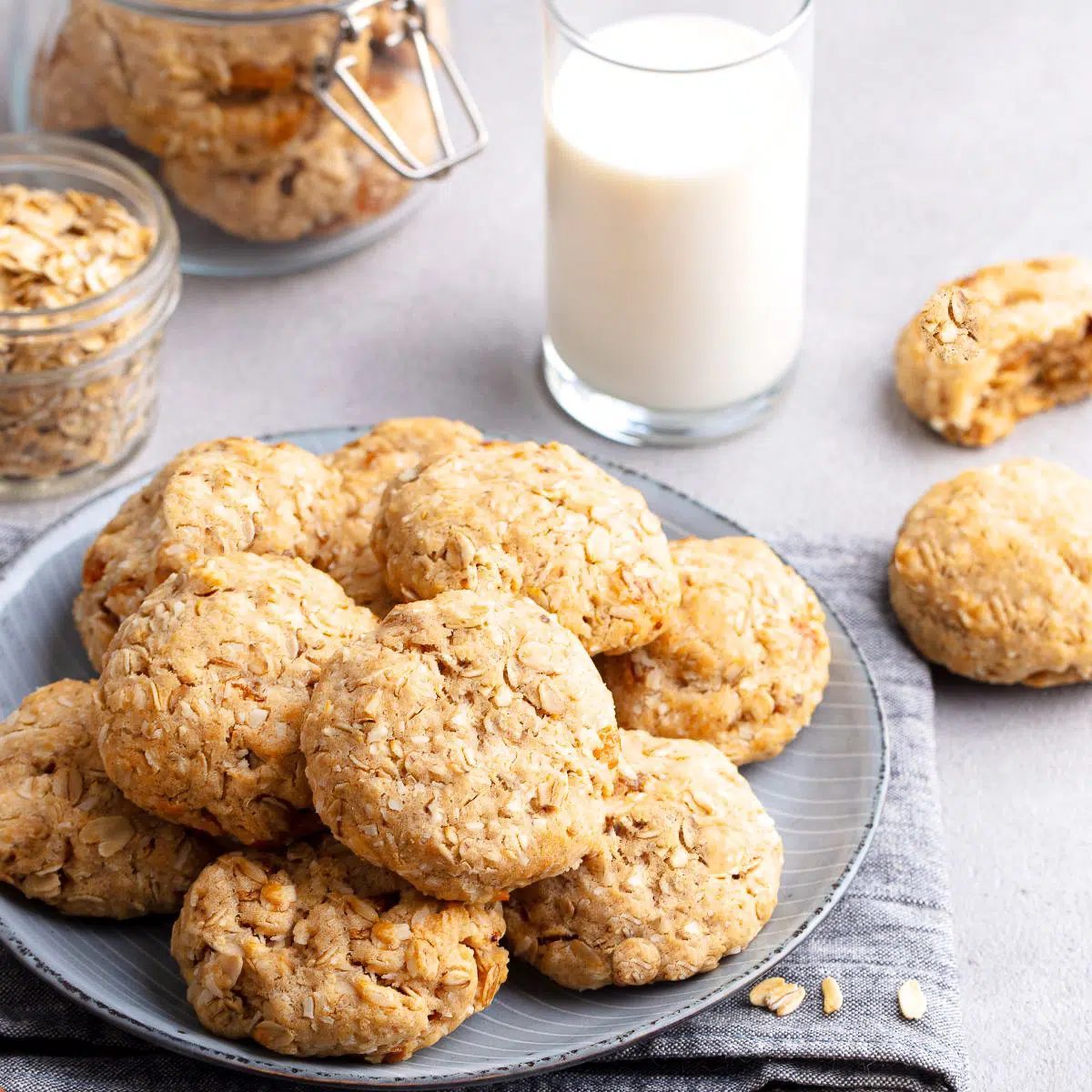 almond butter oat flour cookies on a plate with a glass of milk in background