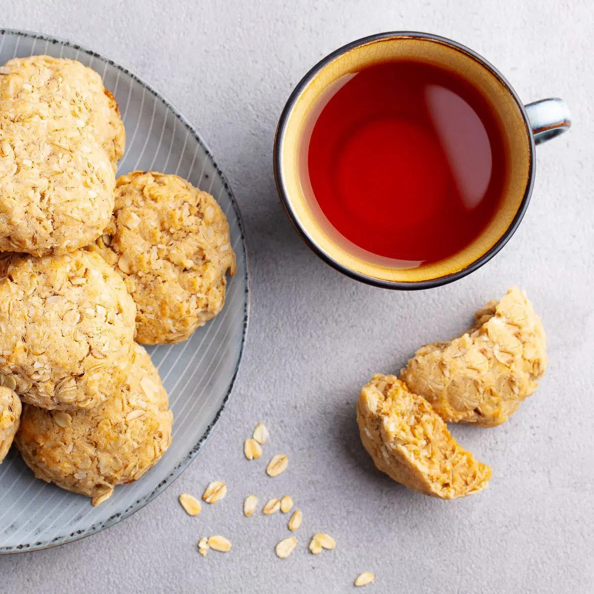 plate of almond oat flour cookies on a are plate, with a cup of tea alongside